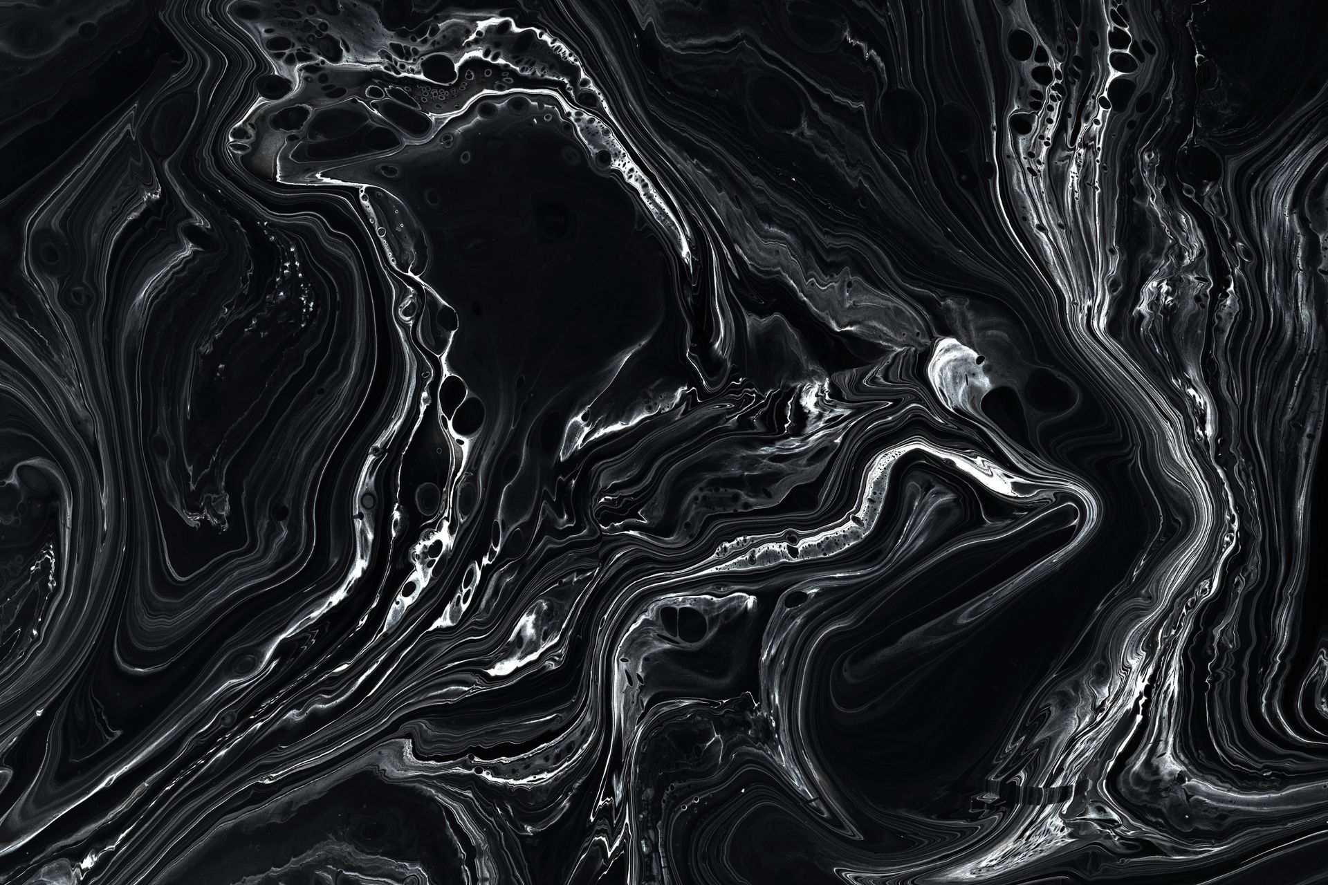 Abstract swirling black and white pattern resembling marble or liquid, with fluid lines. Abstract swirling black and white pattern resembling marble or liquid, with fluid lines.