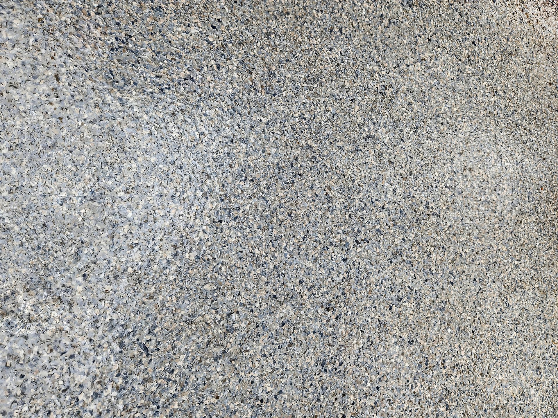 Gray, textured surface with small, granular particles. Gray, textured surface with small, granular particles.