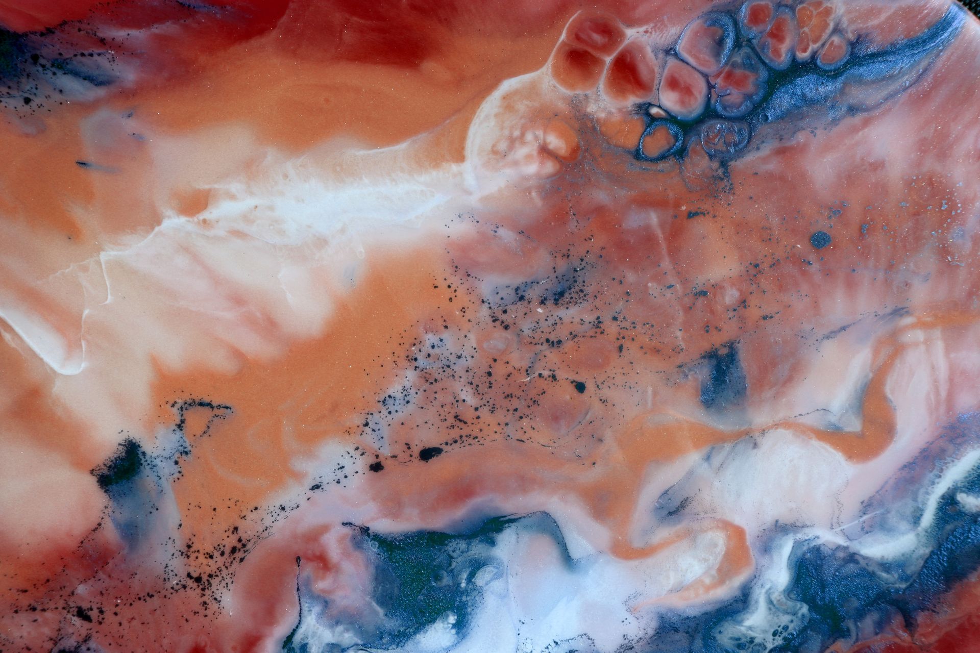 Abstract artwork with swirling orange, blue, and white hues. Dark speckles and bubbly textures add depth. Abstract artwork with swirling orange, blue, and white hues. Dark speckles and bubbly textures add depth.