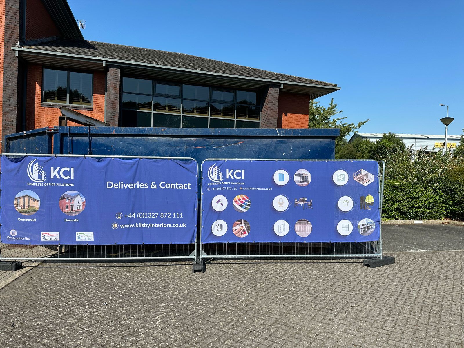A blue banner with the word kci on it is sitting in front of a building.