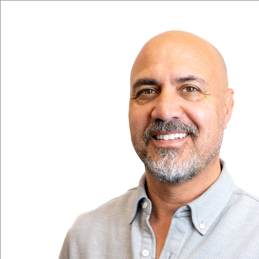 A bald man with a beard is smiling for the camera