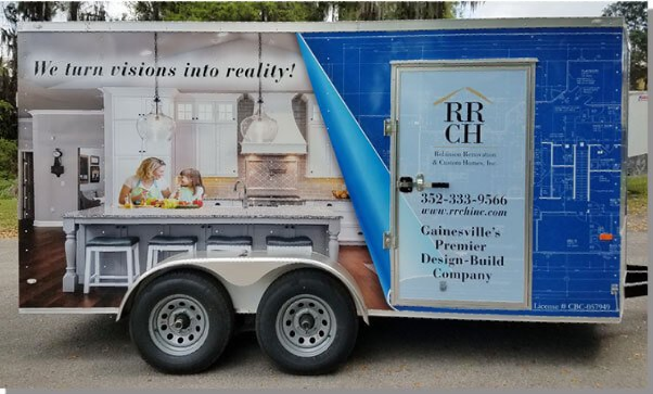 A trailer with RRCH design advertisement; blue blueprint background with kitchen picture.