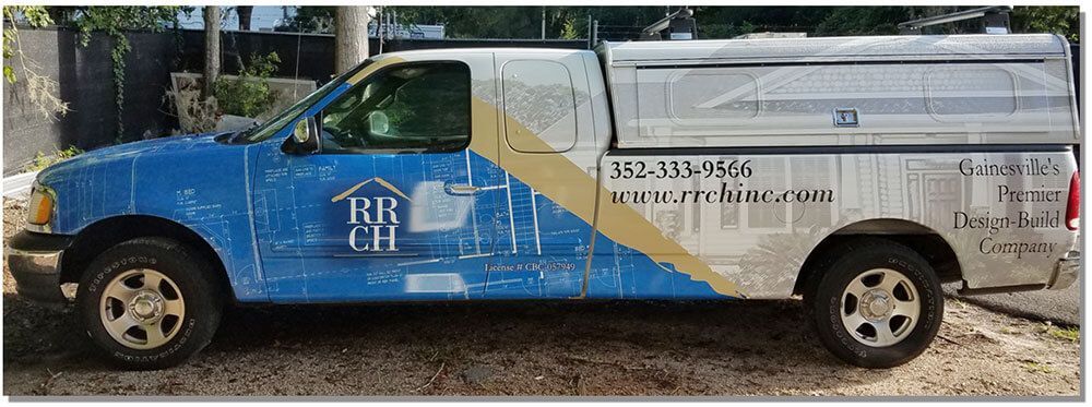Blue and white pickup truck with company logo and contact information on its side.