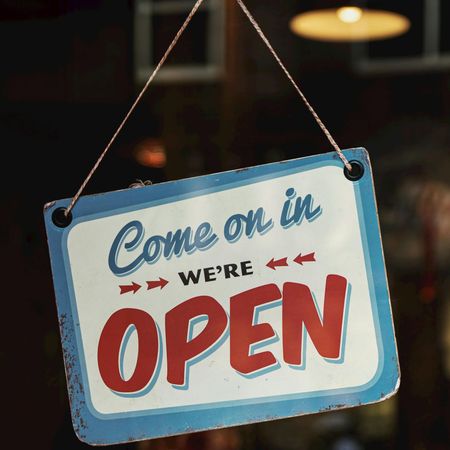 White sign with blue borde for a business with words in red saying 