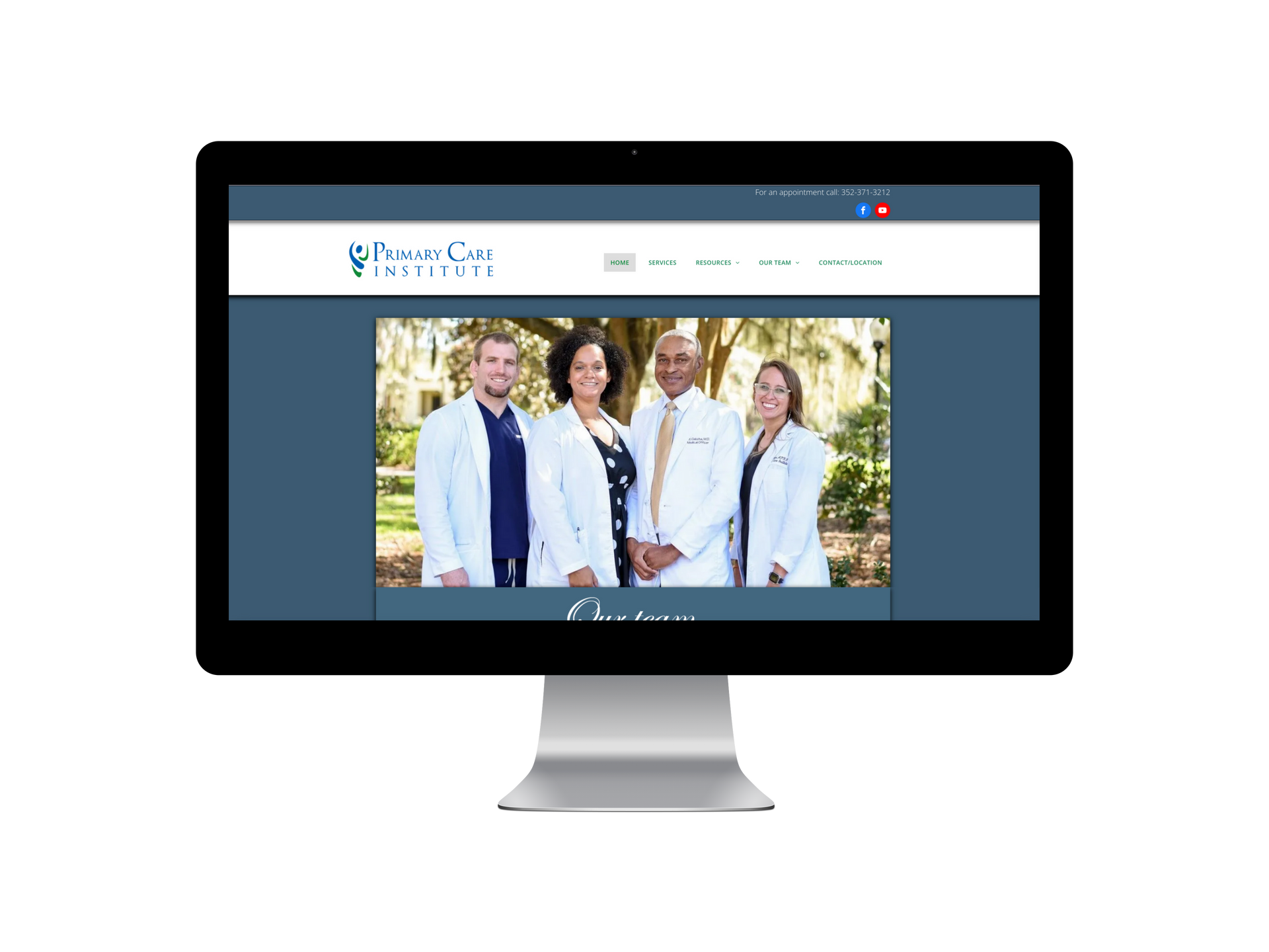 Website on a monitor featuring a group of people wearing lab coats, in front of a tree.