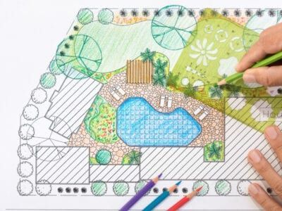 A person is drawing a landscape with colored pencils.