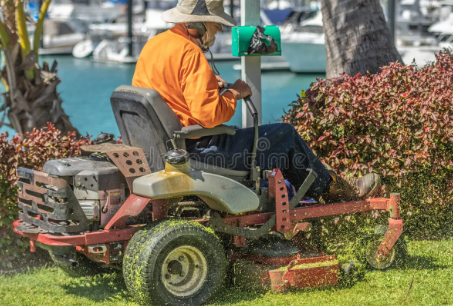 A man is riding a lawn mower in a yard.