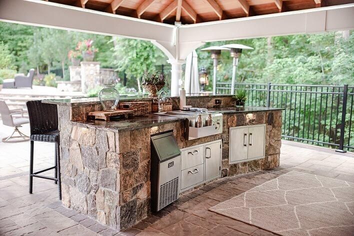 A large outdoor kitchen with a large island in the middle of it.