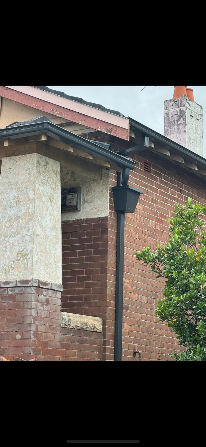 A Brick Building With a Gutter on the Side of It — DC Roofing In Marsden Park, NSW