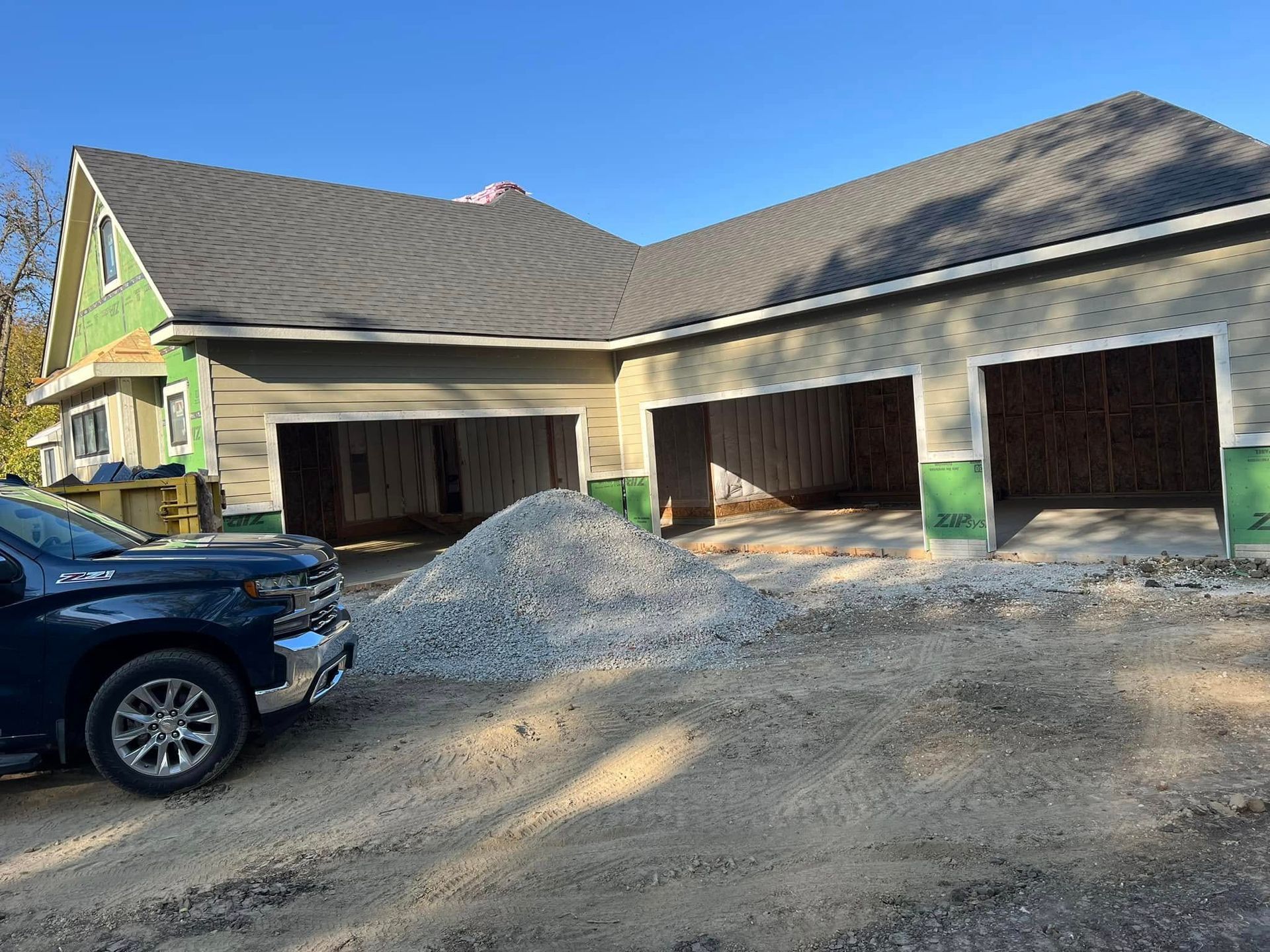 A truck is parked in front of a house under construction.