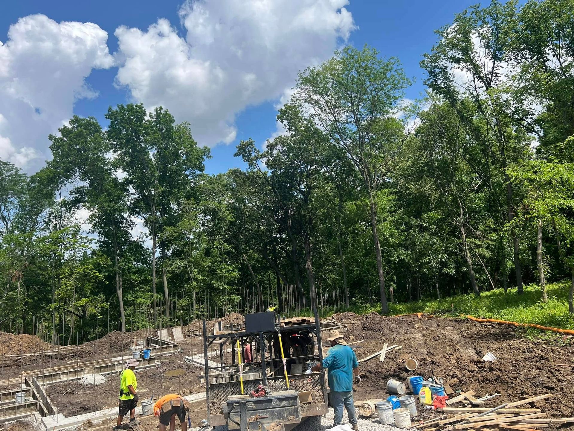 A group of construction workers are working on a construction site in the woods.