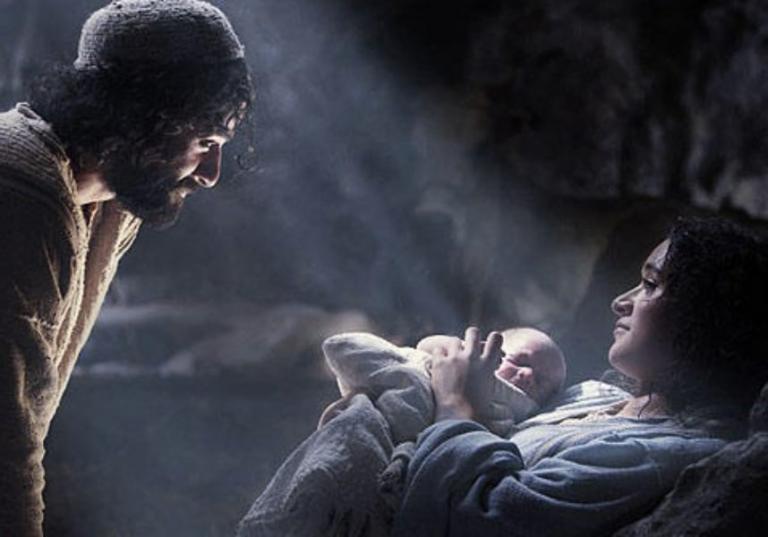 Mary and Joseph gazing at newborn baby Jesus in a dimly lit stable.