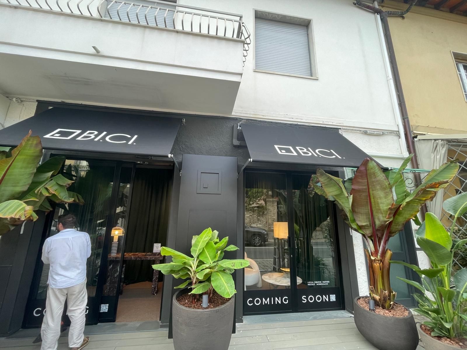 Vetrina con tenda da sole nera e cartello