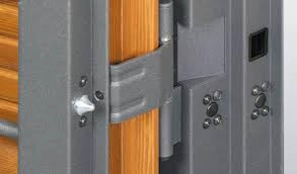 Telaio e cerniera in metallo grigio su una porta in legno, con più meccanismi di chiusura.