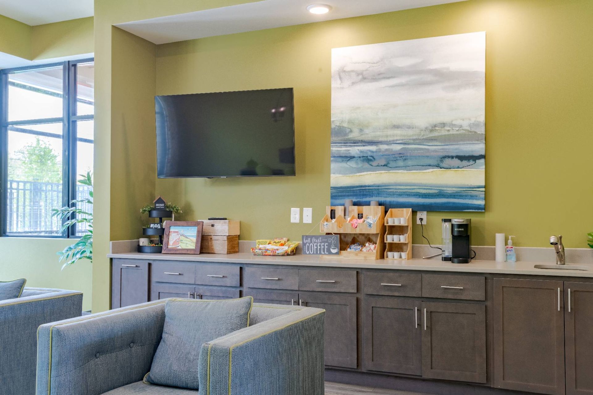 Community lounge with a wall-mounted TV, coffee station, and seating. At Waxhaw Mills, our apartments for rent in Waxhaw, NC offer the best in service and enviable amenities. Experience all our community has to offer. Contact us to set up a tour!