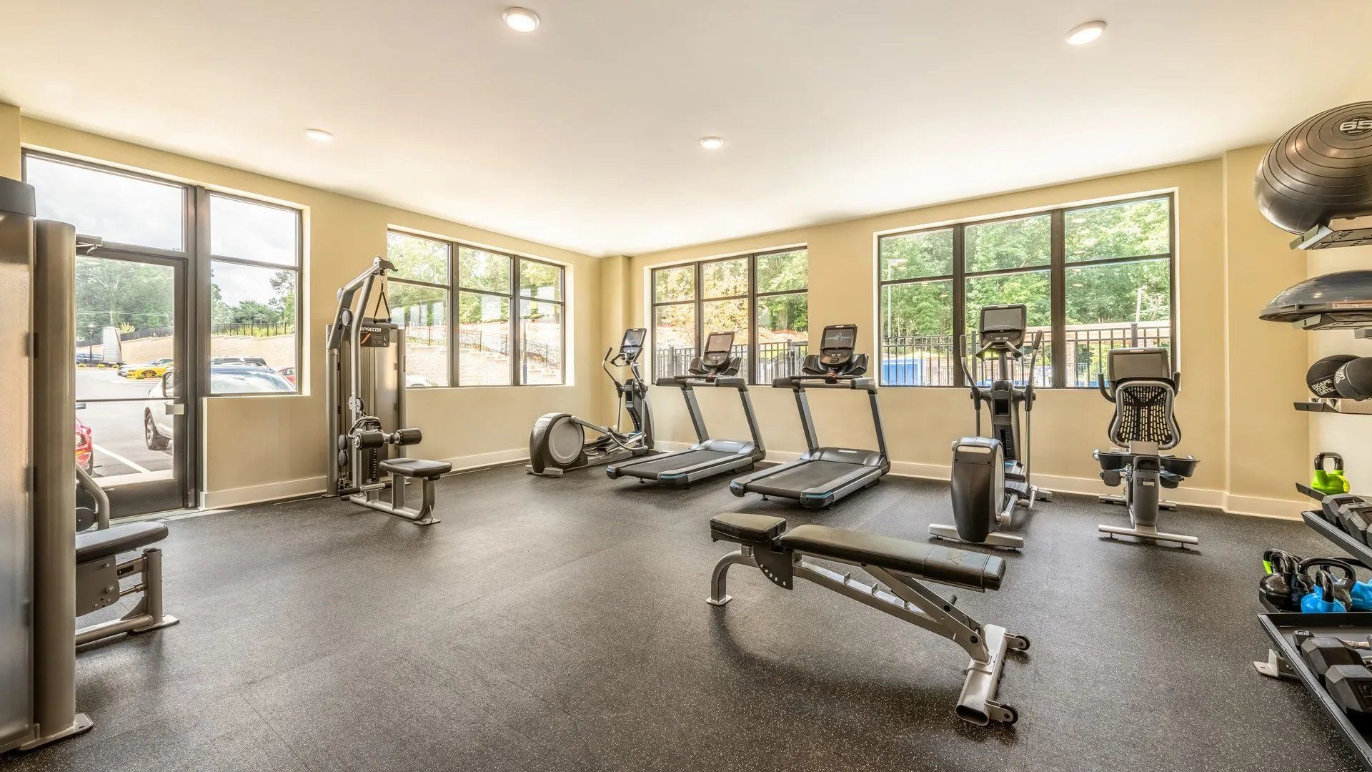 Bright and open gym area with various exercise equipment and large windows. Our Wexhaw, NC apartments provide the best in luxury living in downtown Waxhaw. Ready to make our community your home? Contact Waxhaw Mills today to learn more and schedule your personalized tour! 