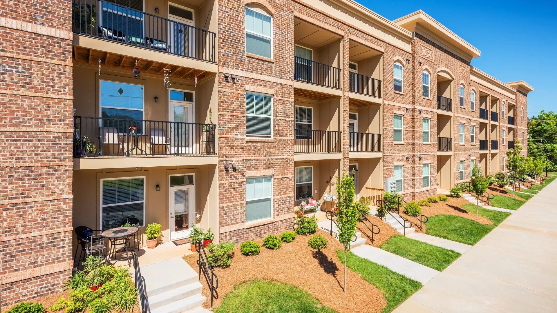 Exterior view of apartment building with balconies and landscaping. Interested in learning more about our 1, 2, and 3-bedroom apartments in Waxhaw, NC? Contact us today to schedule your tour!