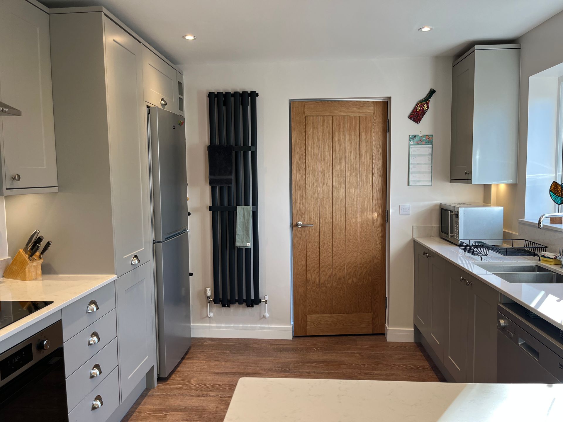 A kitchen with stainless steel appliances and a wooden door