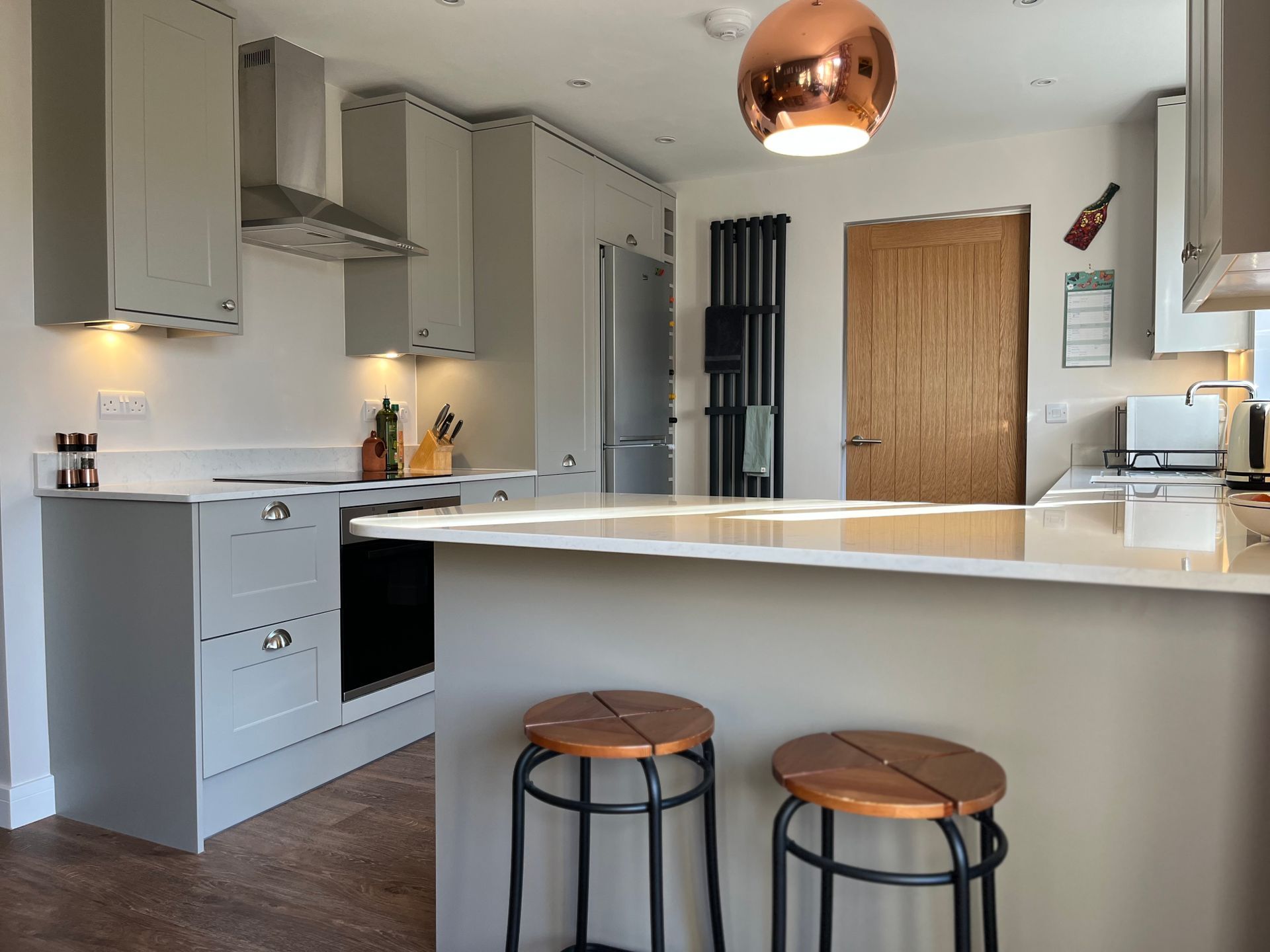 A kitchen with a large island and two stools.