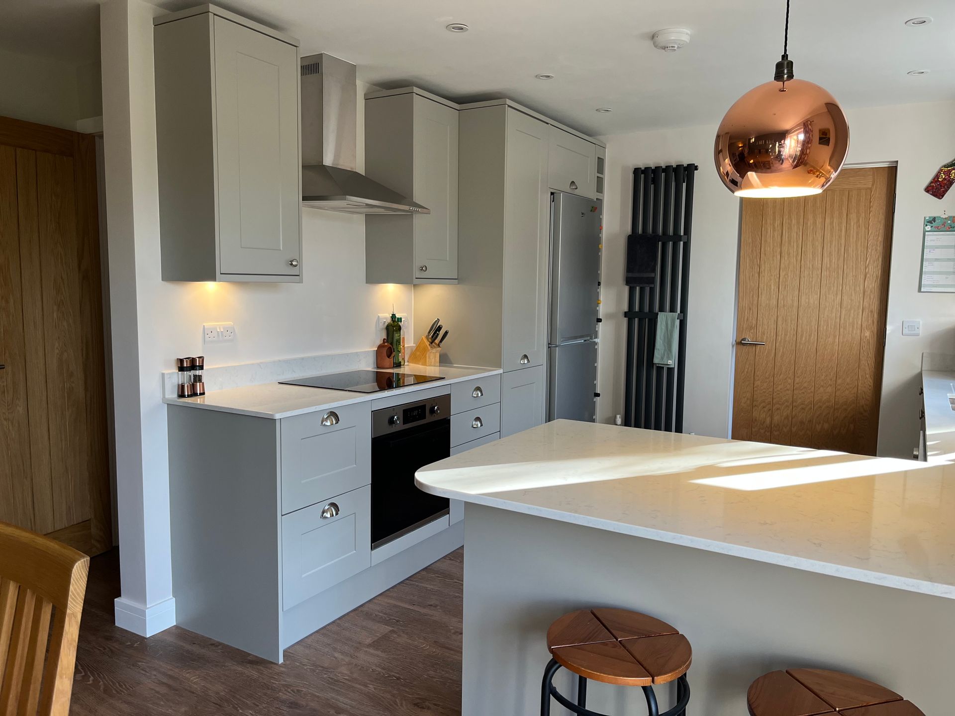 A kitchen with a copper pendant light hanging from the ceiling.