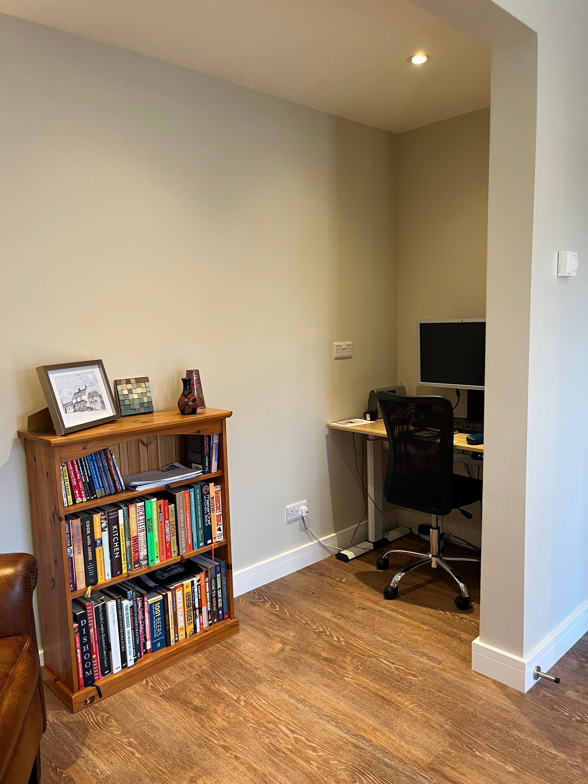 A living room with a bookshelf filled with books and a desk.