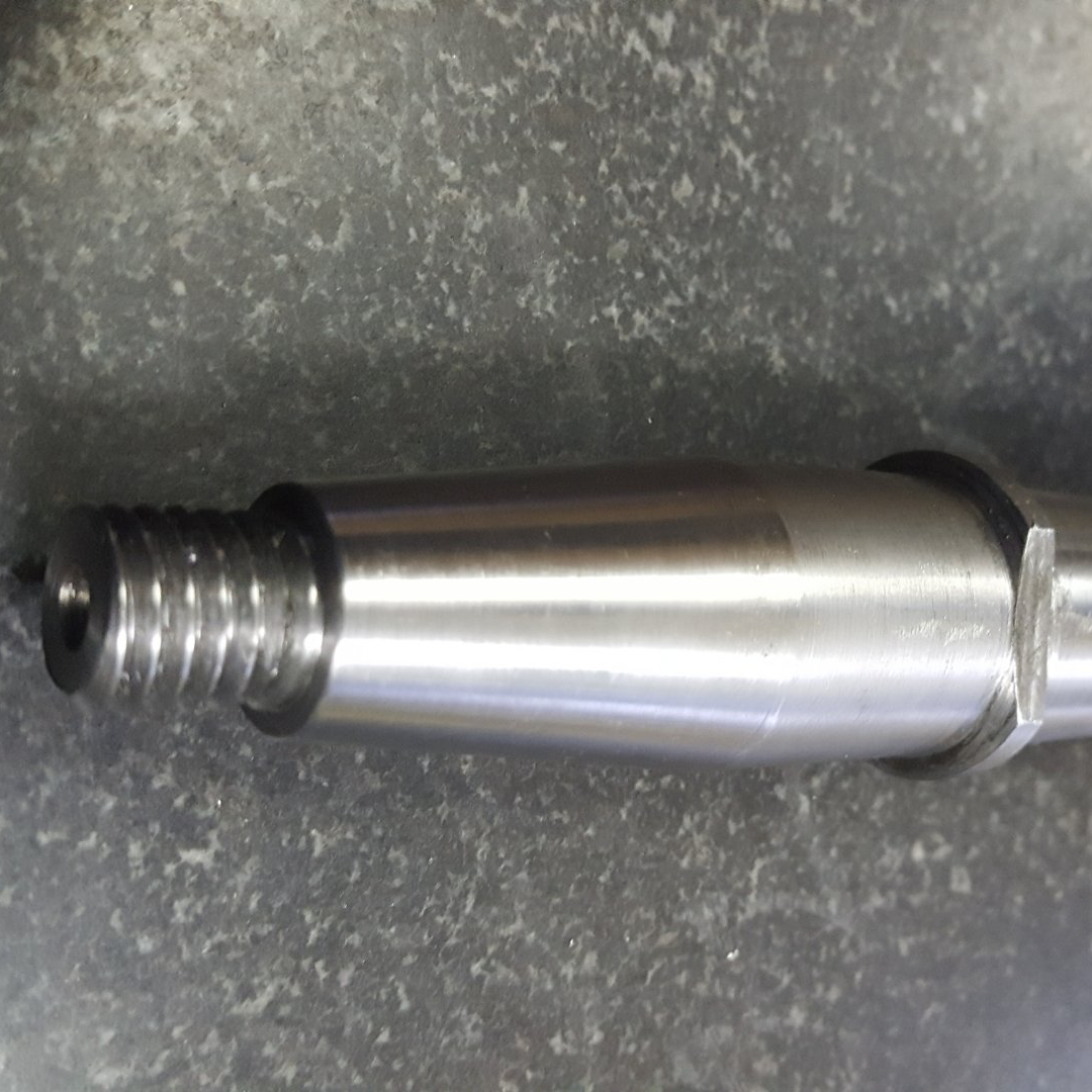 A close up of a metal shaft on a table.