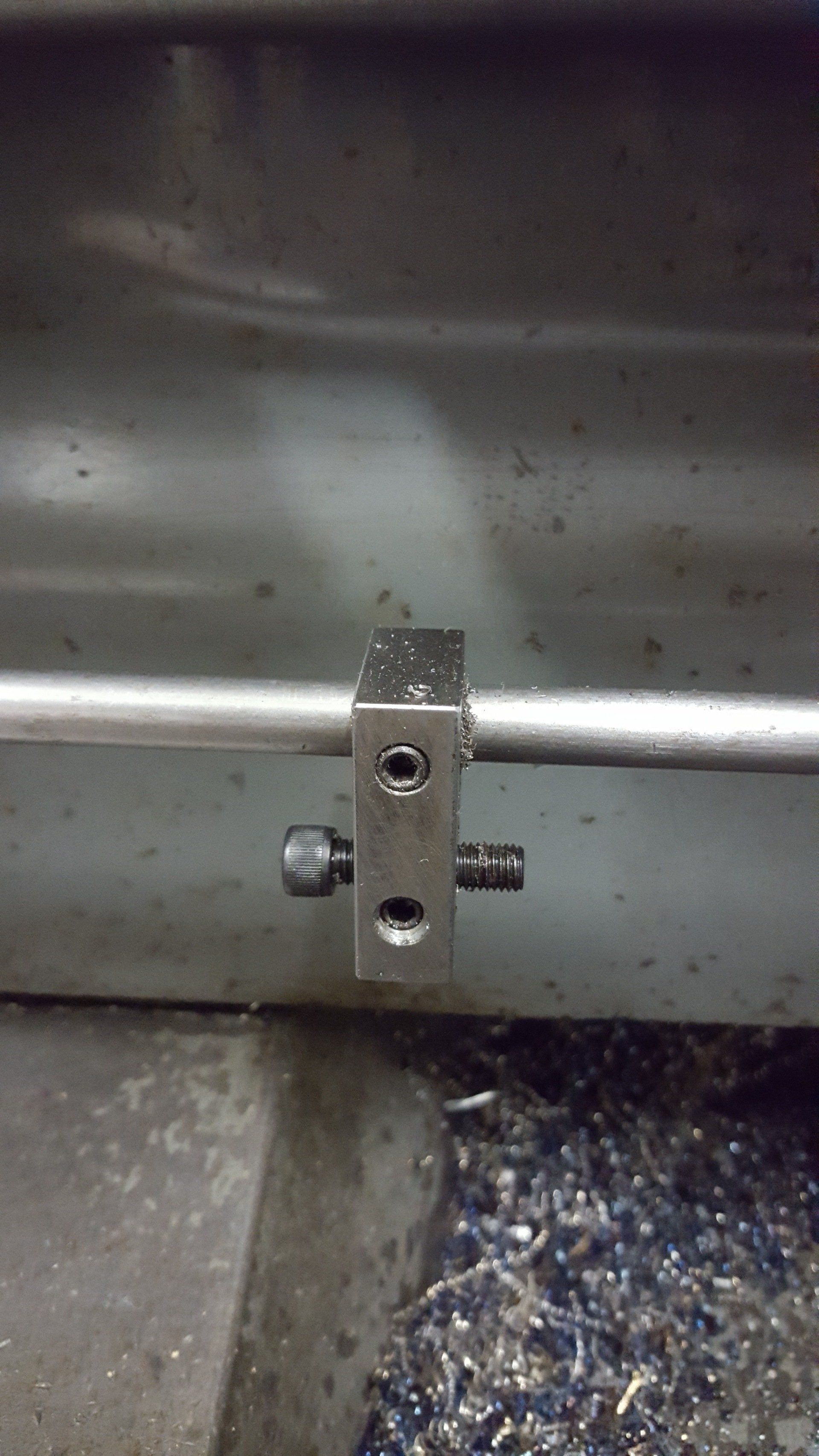 A metal pipe is sitting on top of a pile of metal shavings.