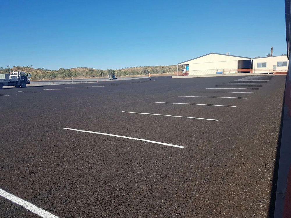 Empty Asphalt Parking Lot With White Painted Lines — Lamont Civil Services Pty Ltd In Mount Isa, QLD