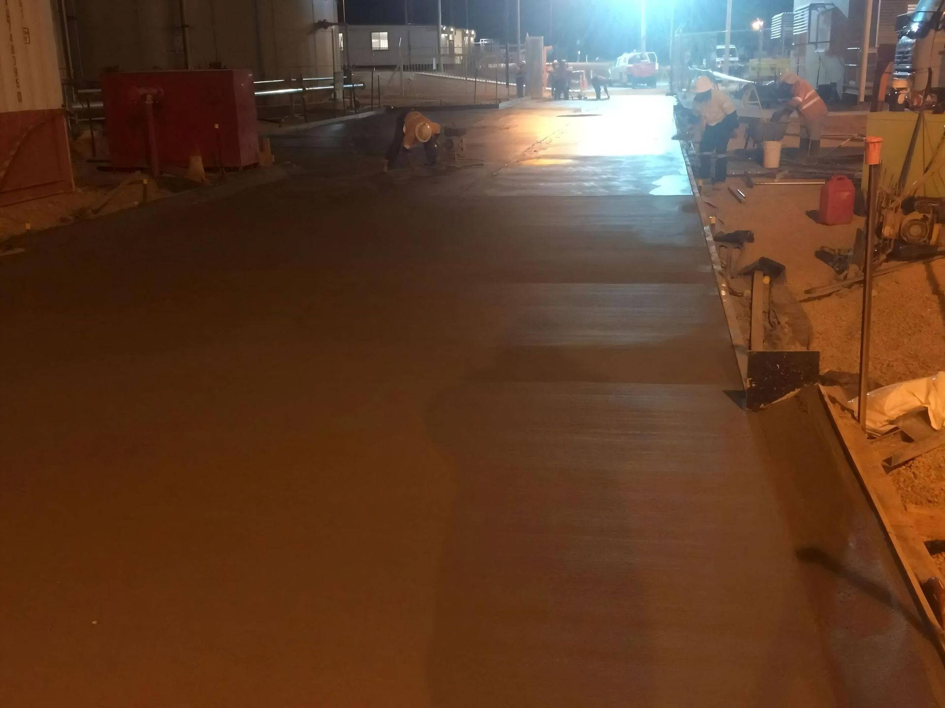 Workers Smoothing Wet Concrete at Night, Lit by Overhead Lights — Lamont Civil Services Pty Ltd In Townview, QLD