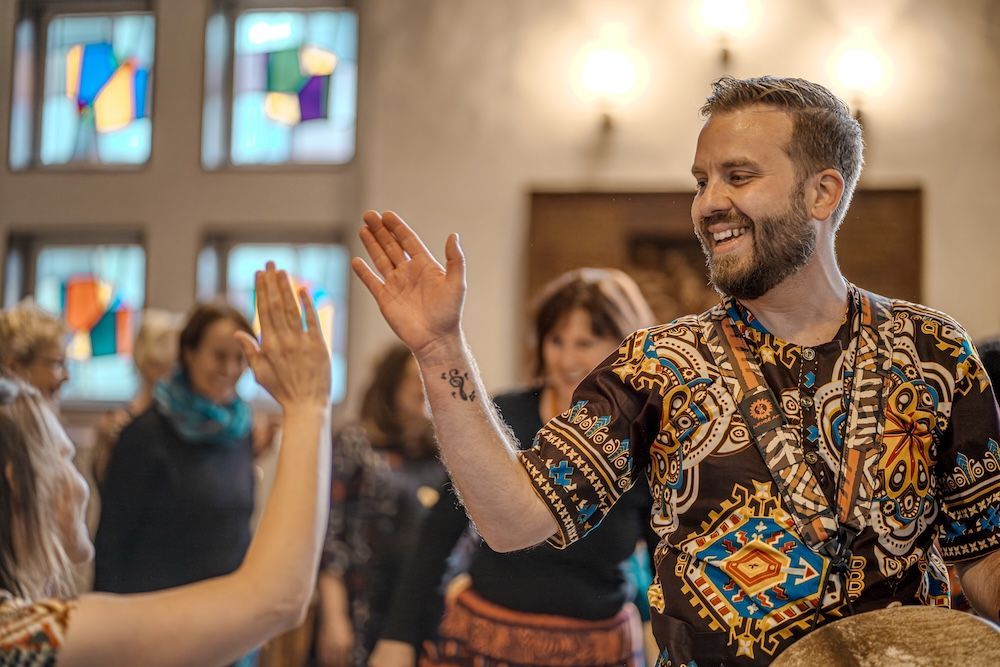 Max-Ole steht singend und trommelnd vor seinem Chor.