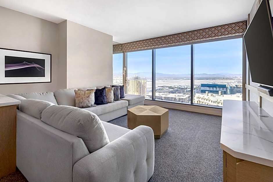 Elara Las Vegas suite with floor to ceiling windows overlooking the Strip skyline at night