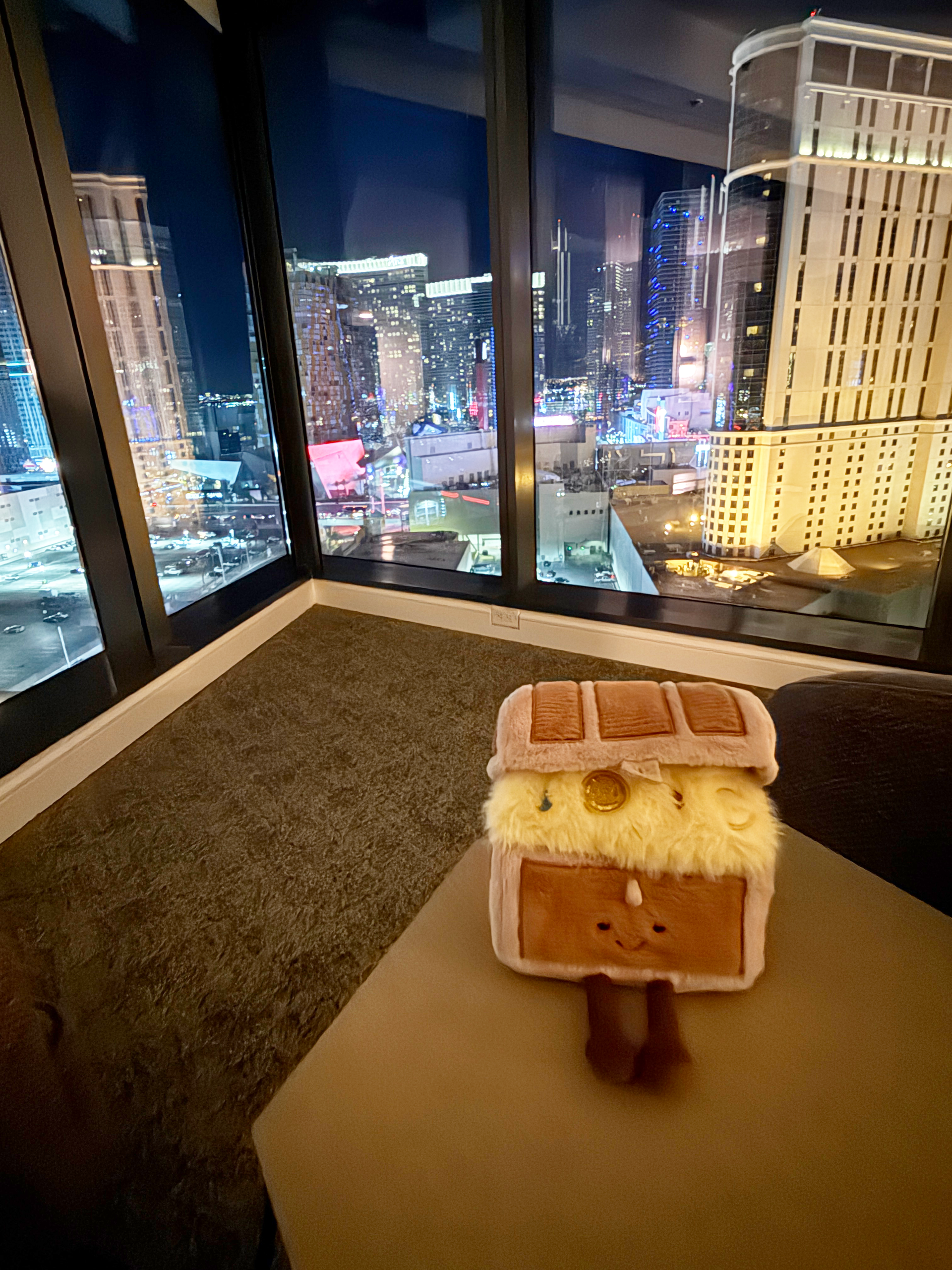 Elara Las Vegas suite with floor to ceiling windows overlooking the Strip skyline at night