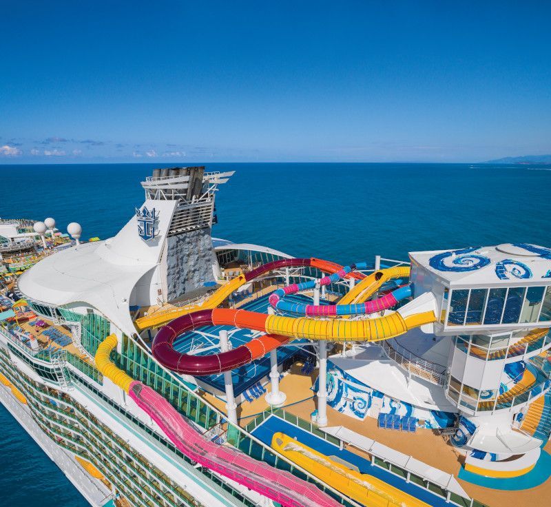Cruise ship with colorful water slides and ocean view.