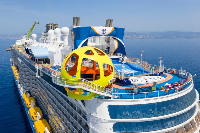 Cruise ship deck with yellow orb-like observation deck. Ocean and sky in background.
