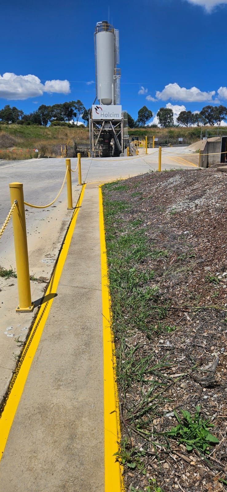 Yellow walkway lines leading to a Holcim silo at the Orange plant