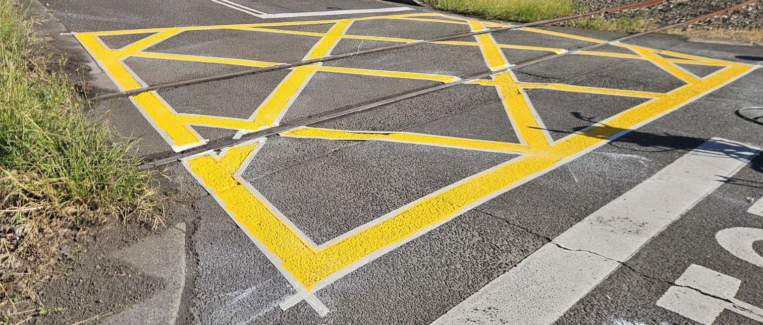 Yellow box marking at a rail crossing with the masking tape still on