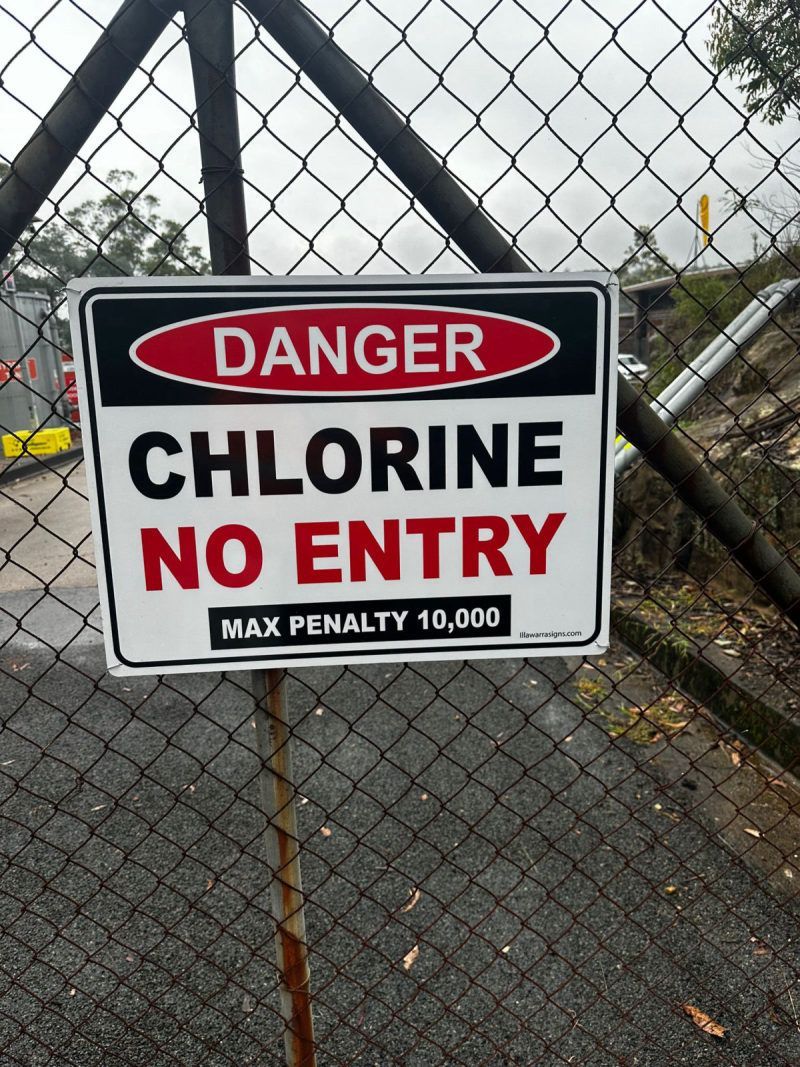 Danger chlorine no entry sign on a fence at a water site