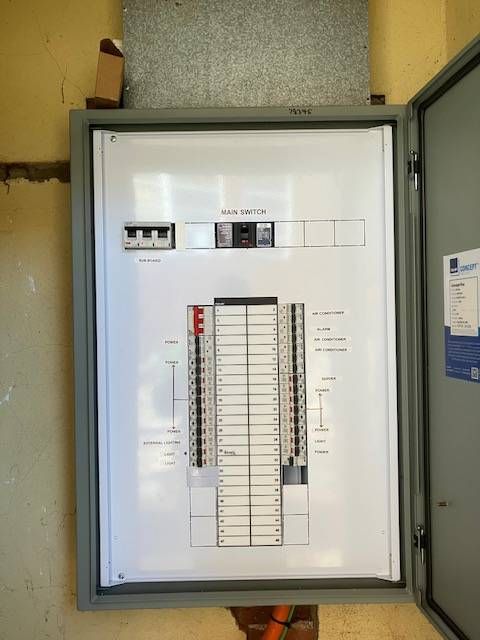 Open grey electrical panel with circuit breakers, wiring diagrams, and a visible main power switch — Todd Basham Electrical in Cootamundra, NSW