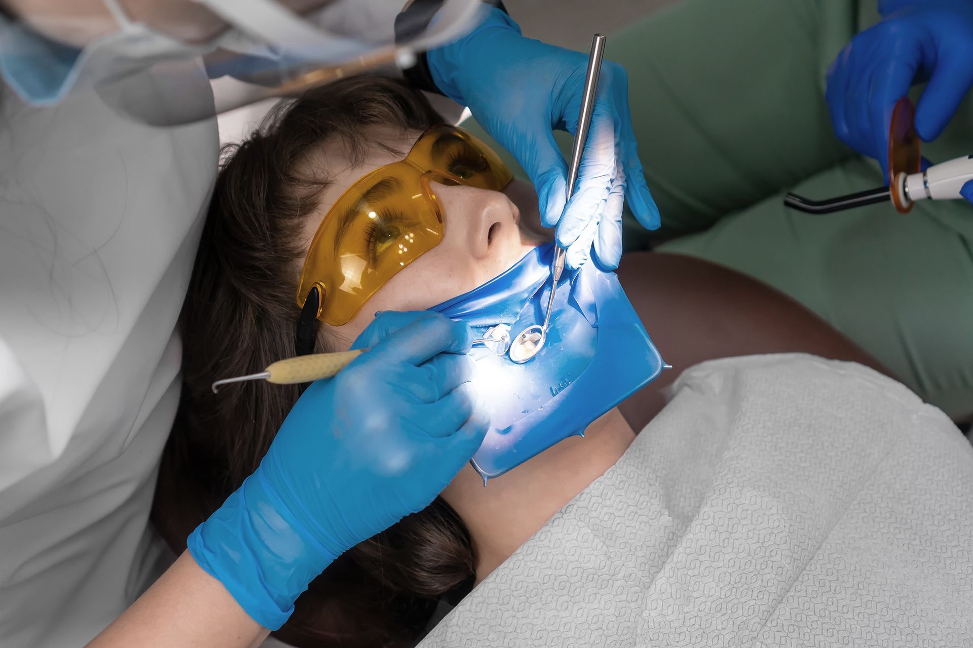 Una mujer está siendo examinada por un dentista.