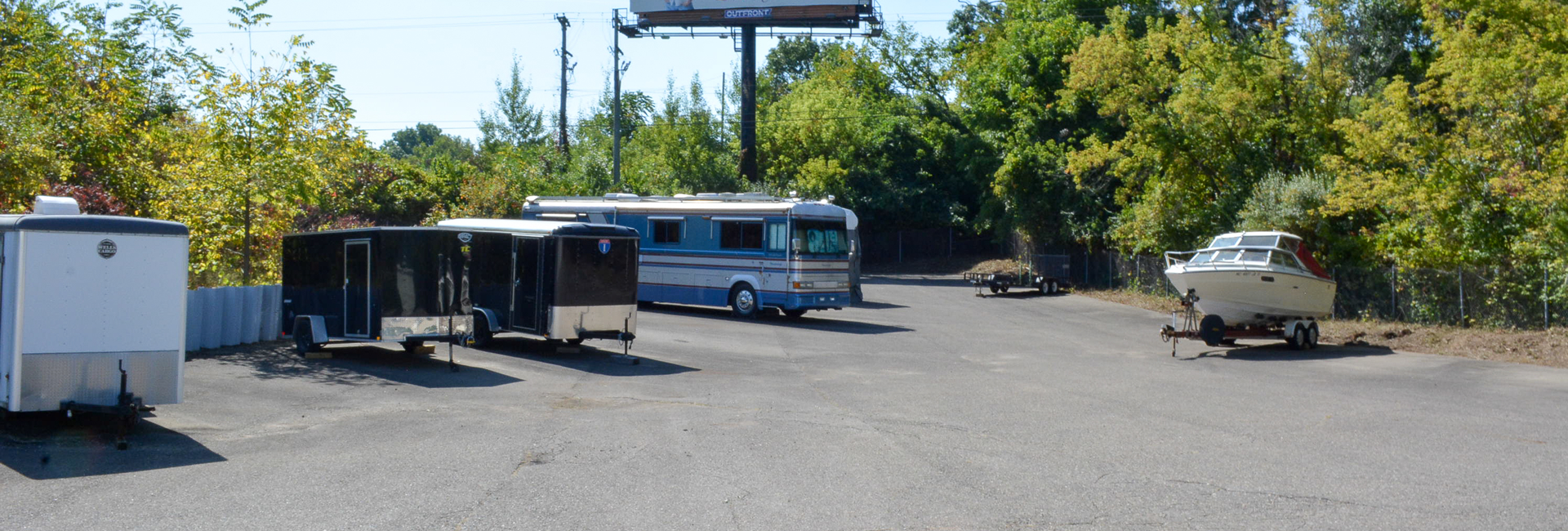 Boat, motorhome, and enclosed trailers parked in the outdoor winter storage lot at Brighton Mini Storage in Brighton, MI