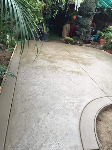 Curved concrete patio surrounded by lush tropical plants and garden greenery