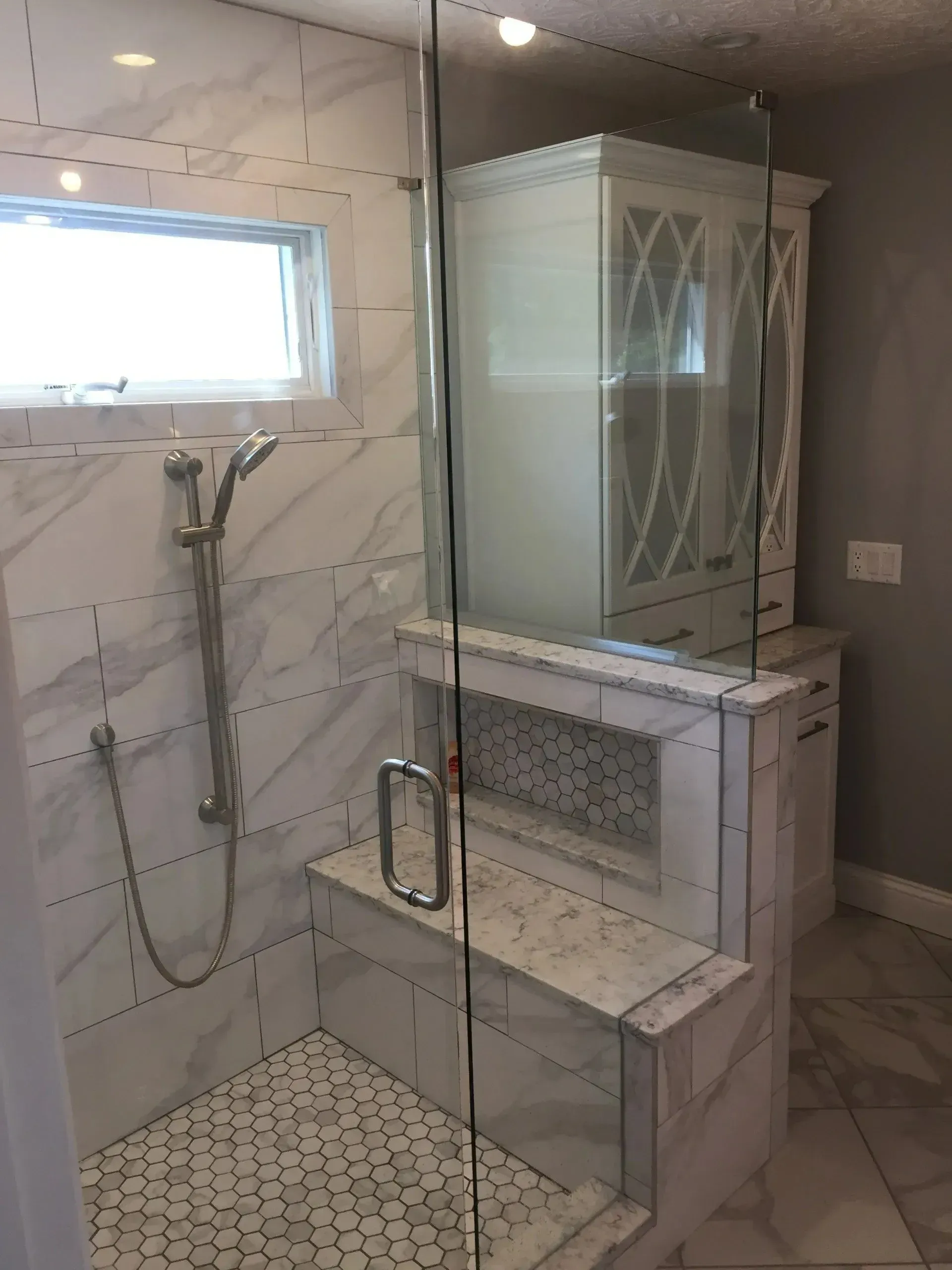A bathroom with a walk in shower and a window