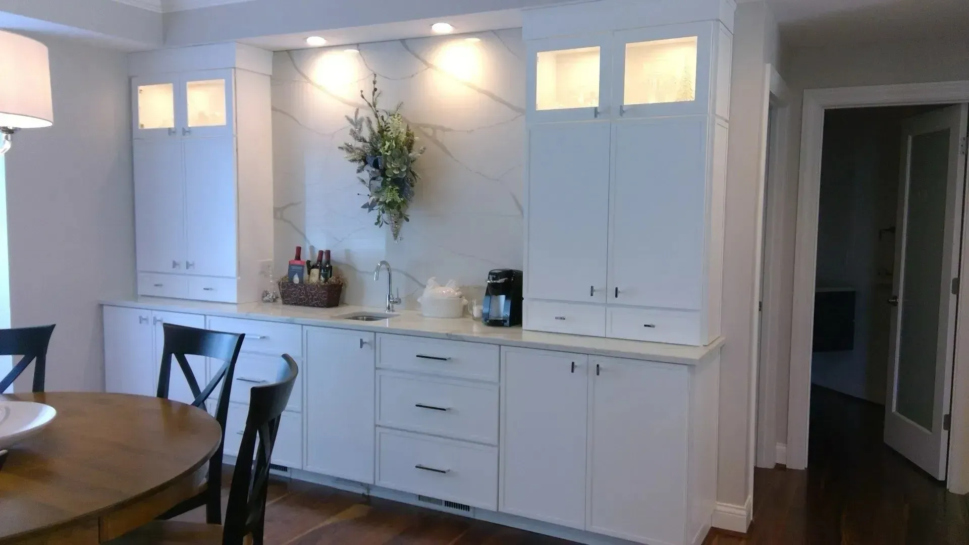 A kitchen with white cabinets and a table and chairs