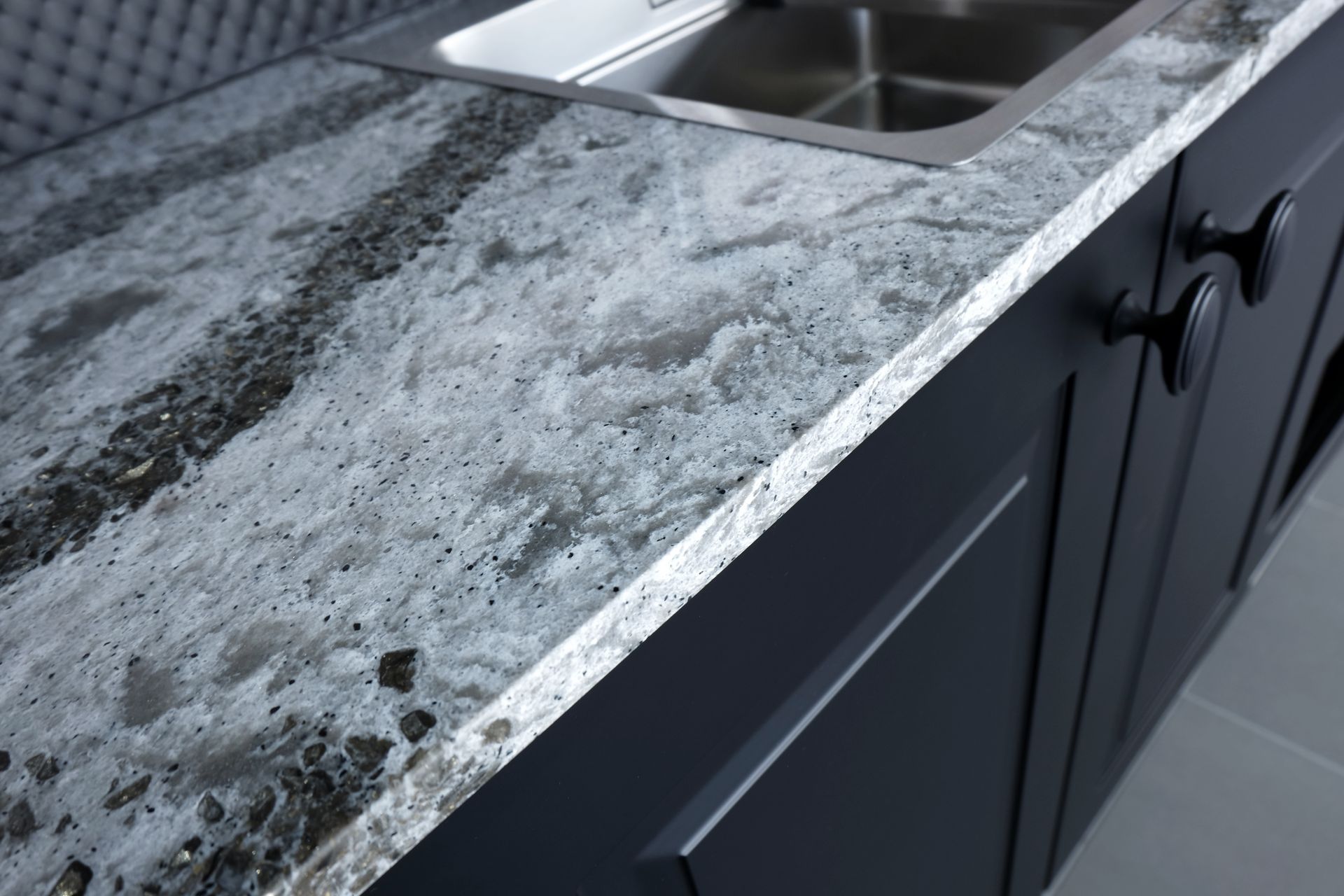 Granite kitchen countertop with stainless steel sink and dark cabinets