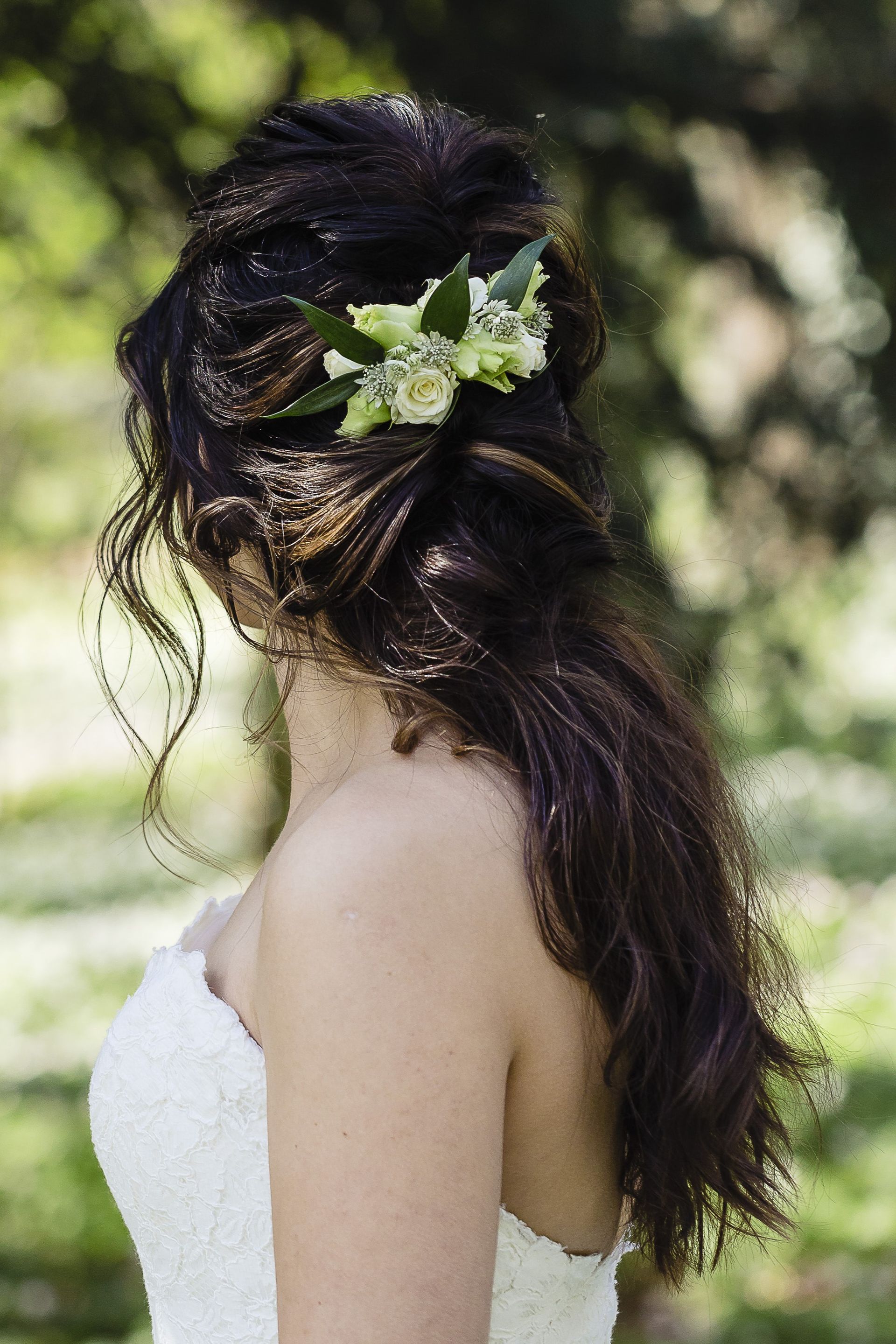 Bohemian bruidskapsel, een volle lage staart met bloemen in haar voor een bruid
