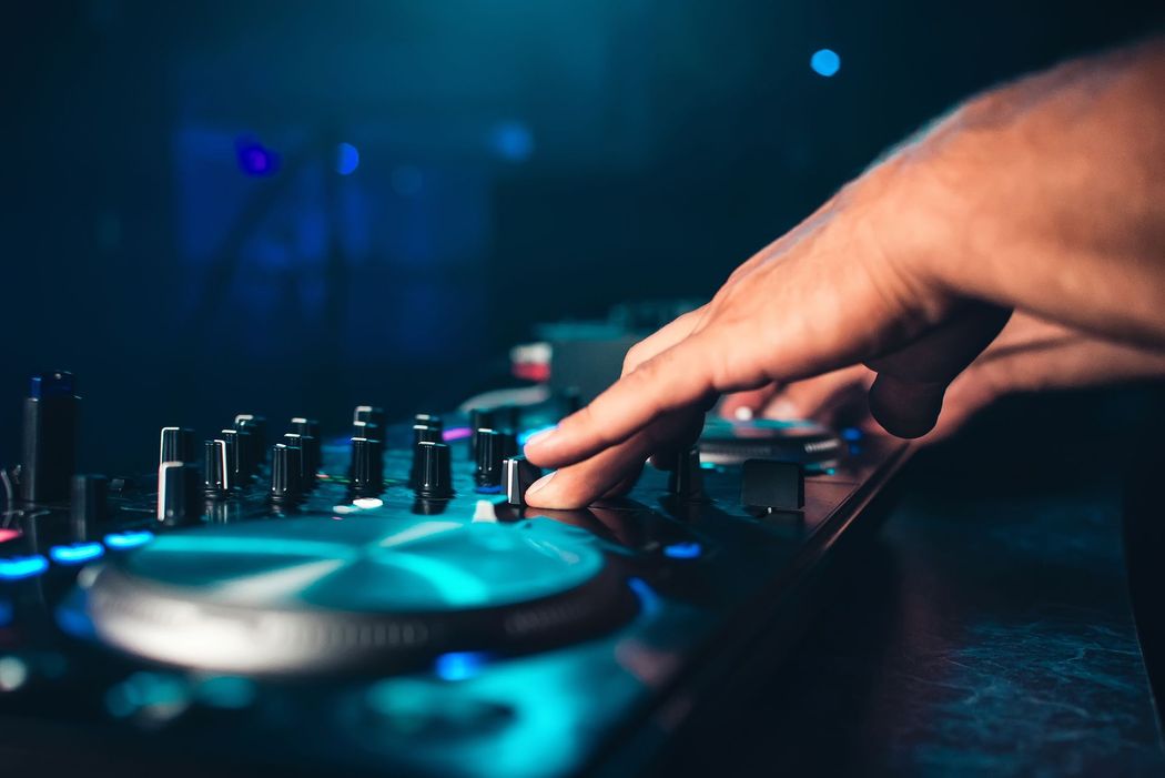 Manopole di regolazione manuale su un mixer da DJ con luci di scena blu