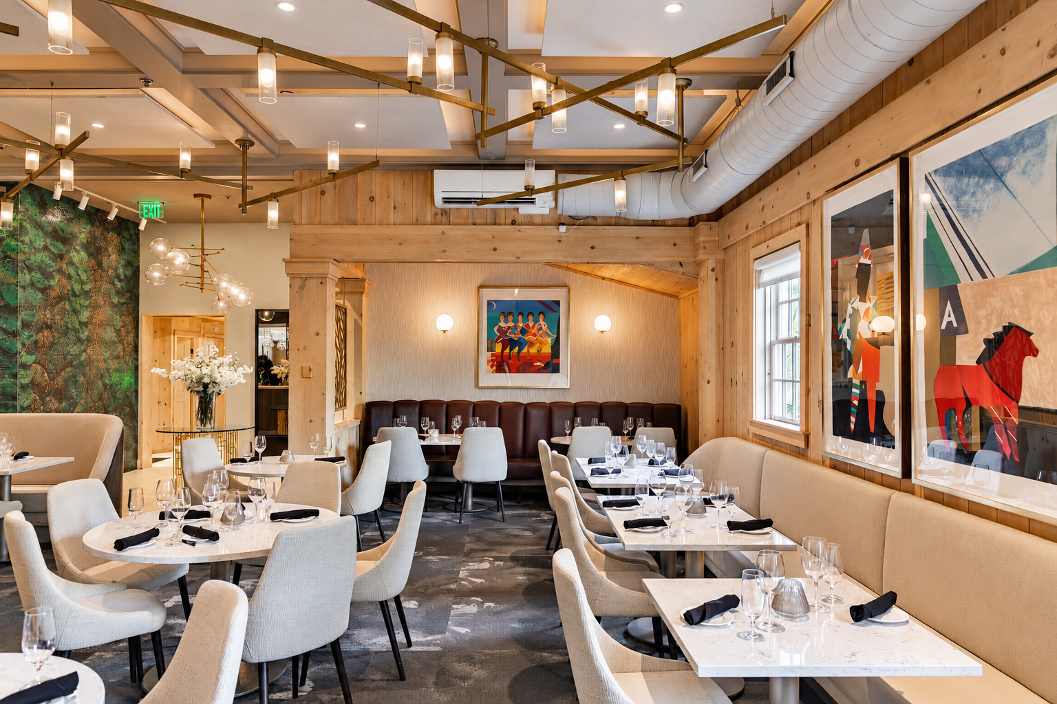 Bright restaurant interior with white table settings, pendant lights, and colorful wall art