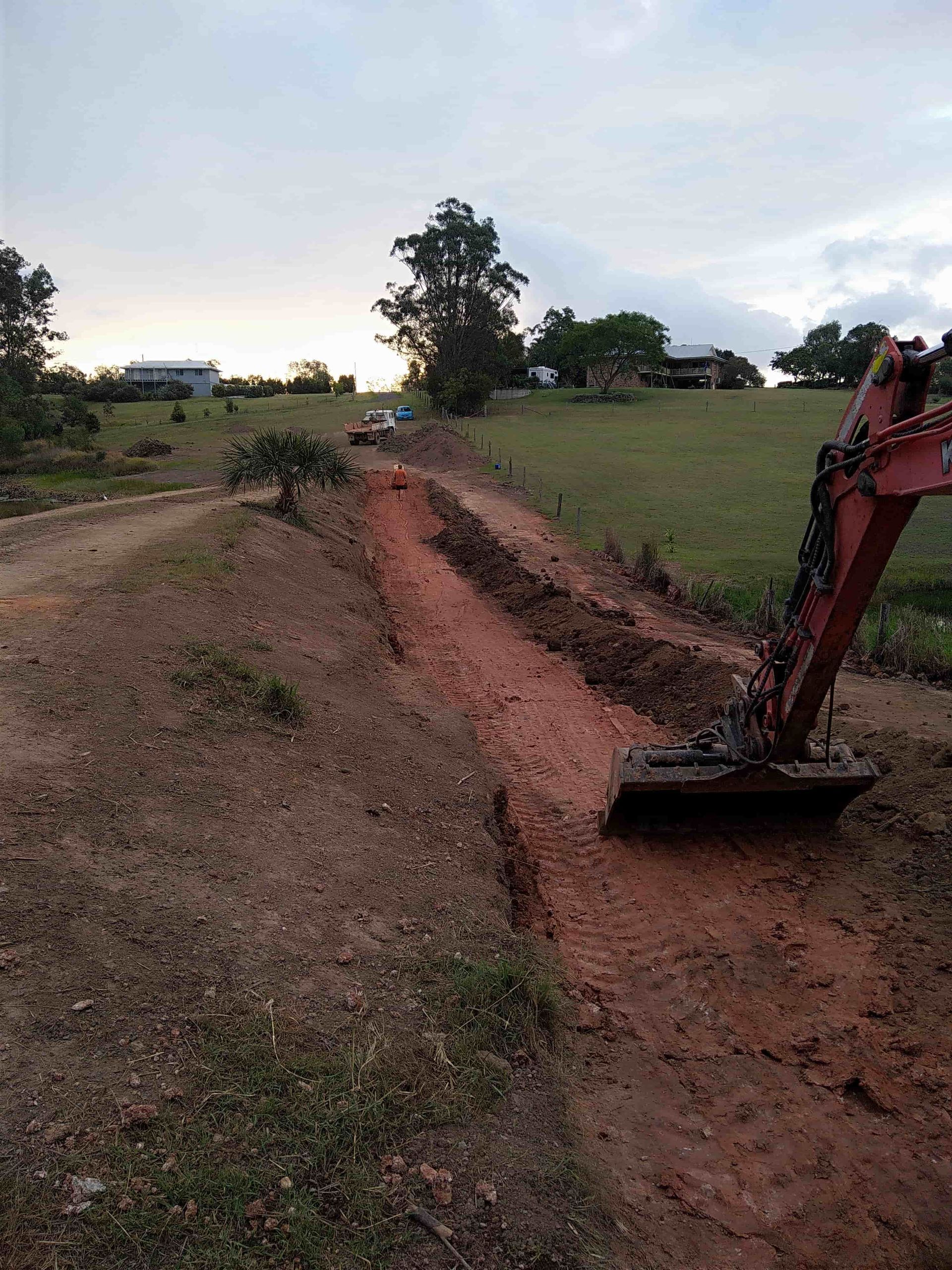 An Excavator Is Digging A Hole In The Dirt On A Dirt Road — Ant's Earthworks In North Deep Creek, QLD 