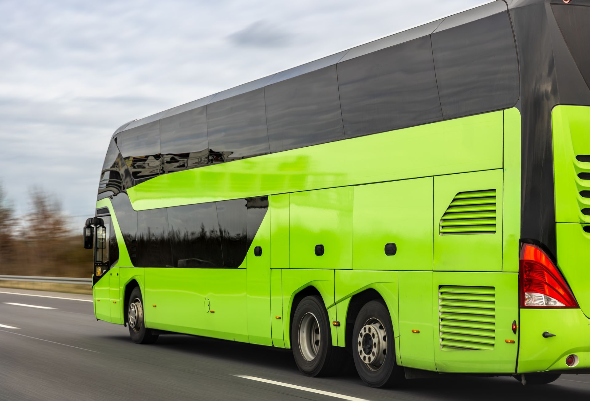 Ljus limegrön dubbeldäckarbuss som kör på en motorväg