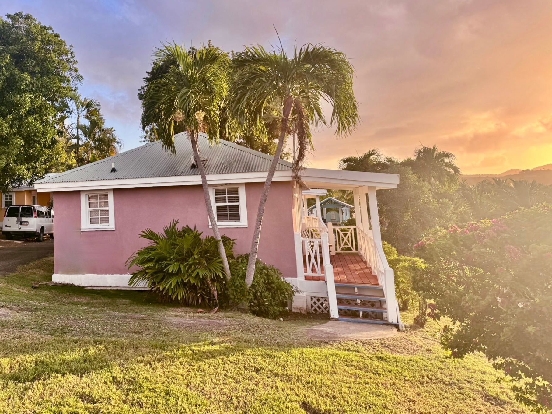 A pink house with a white van parked in front of it